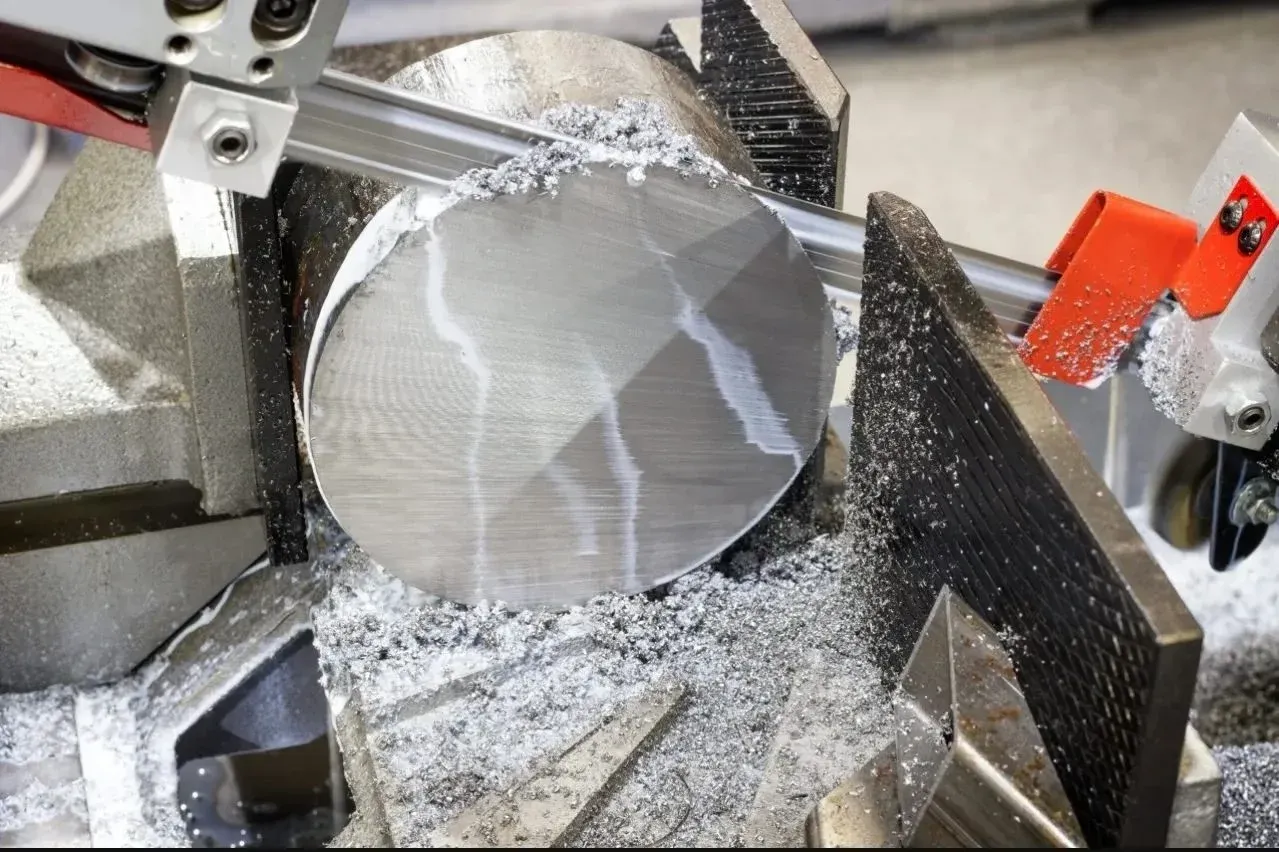 Band saw cutting round aluminum bar stock