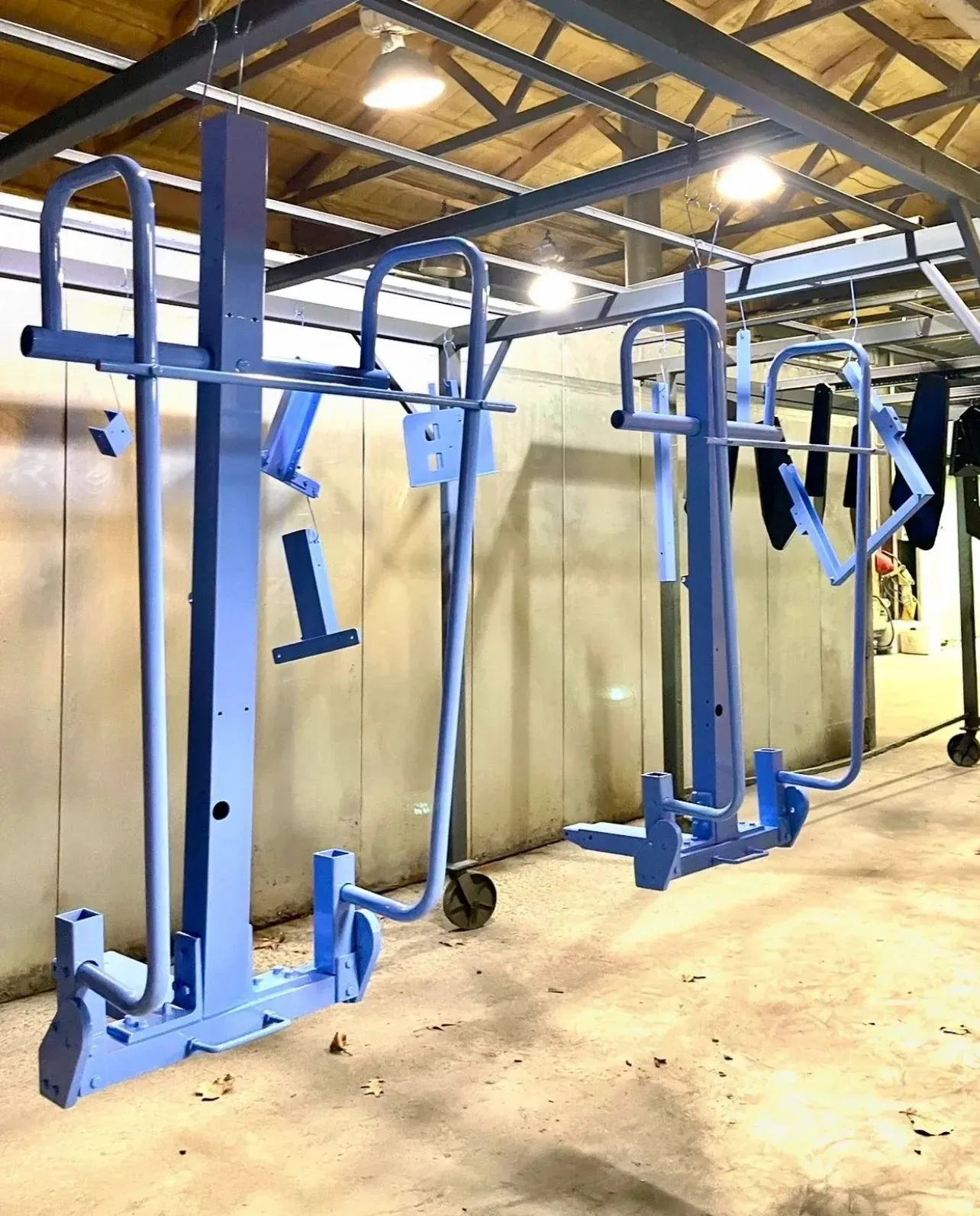 Freshly powder-coated blue cart frames hanging on the line
